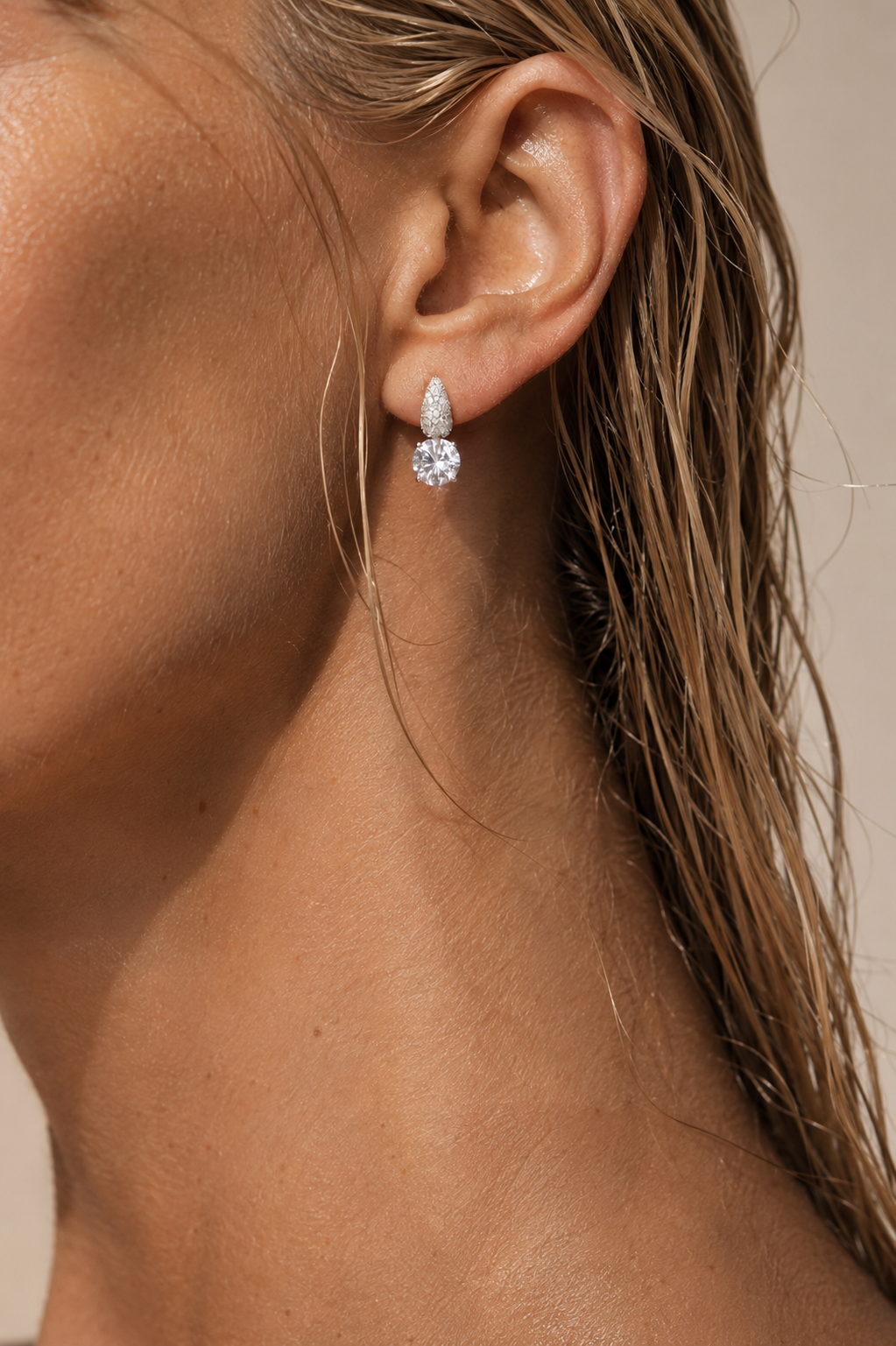 Close-up cu cercei din argint rodiat și moissanite pe model blond